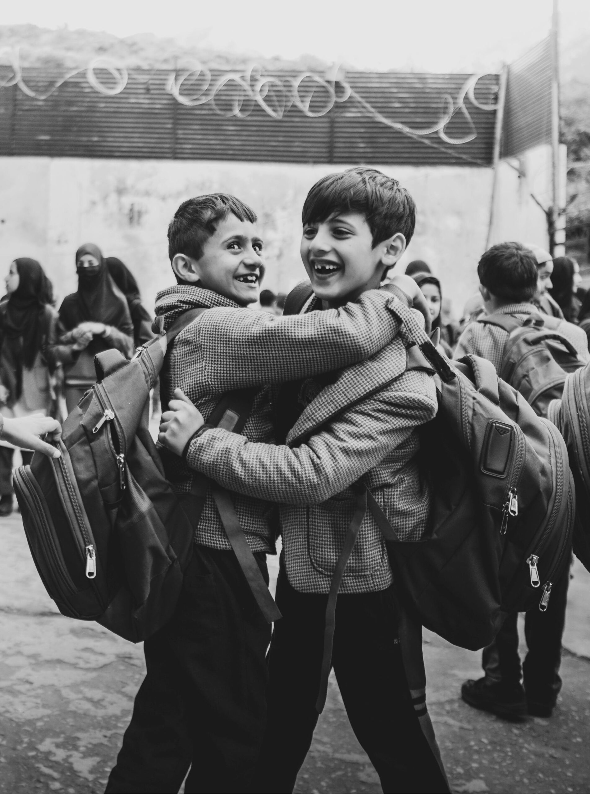 Two young friends hugging and laughing, illustrating the joy of genuine workplace connection and friendship